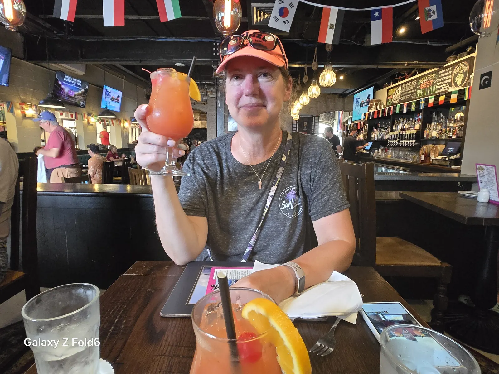 the cruise hq cruiser raising a rum swizzle across a lunch table in a pub at royal naval dockyard bermuda