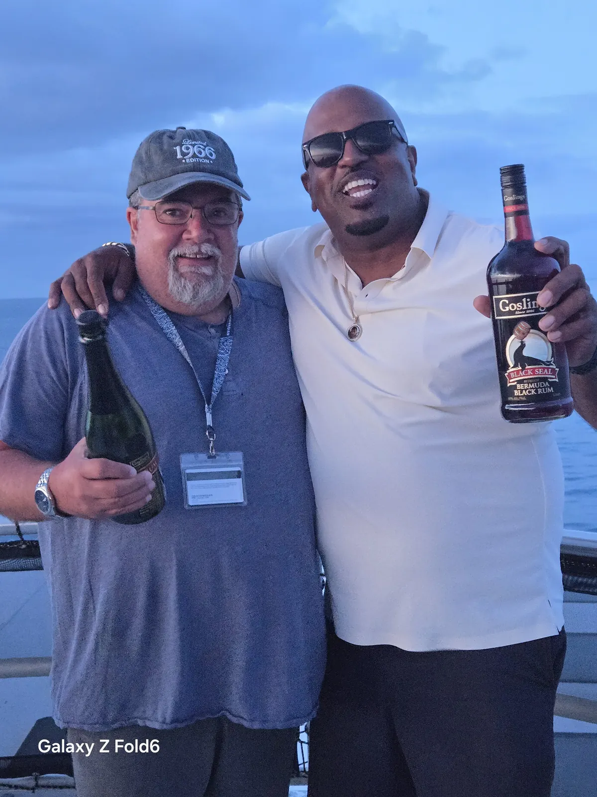 the cruise hq cruise guest and boat host holding a bottle of gosling's black seal rum on a bermuda rum cruise