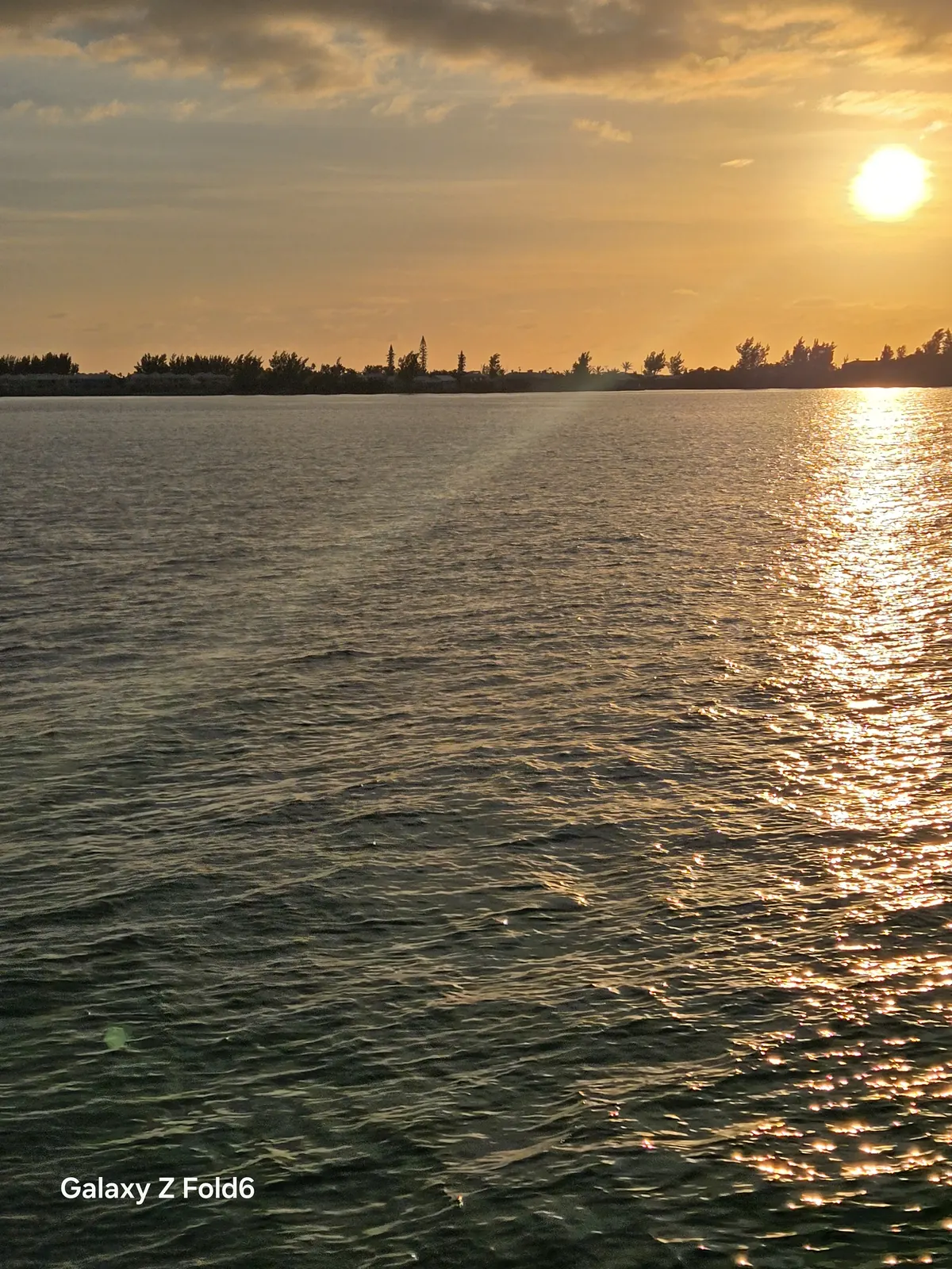 the cruise hq golden sunlight reflecting off the water of the great sound with a low bermuda shoreline