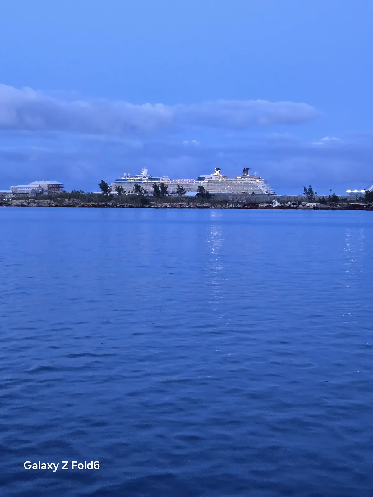 the cruise hq two cruise ships docked at royal naval dockyard seen from the water at dusk
