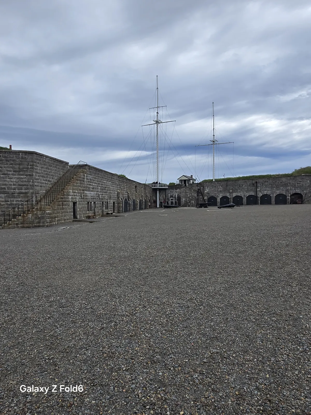 the cruise hq parade square framed by stone walls with two signal masts in the distance at halifax citadel