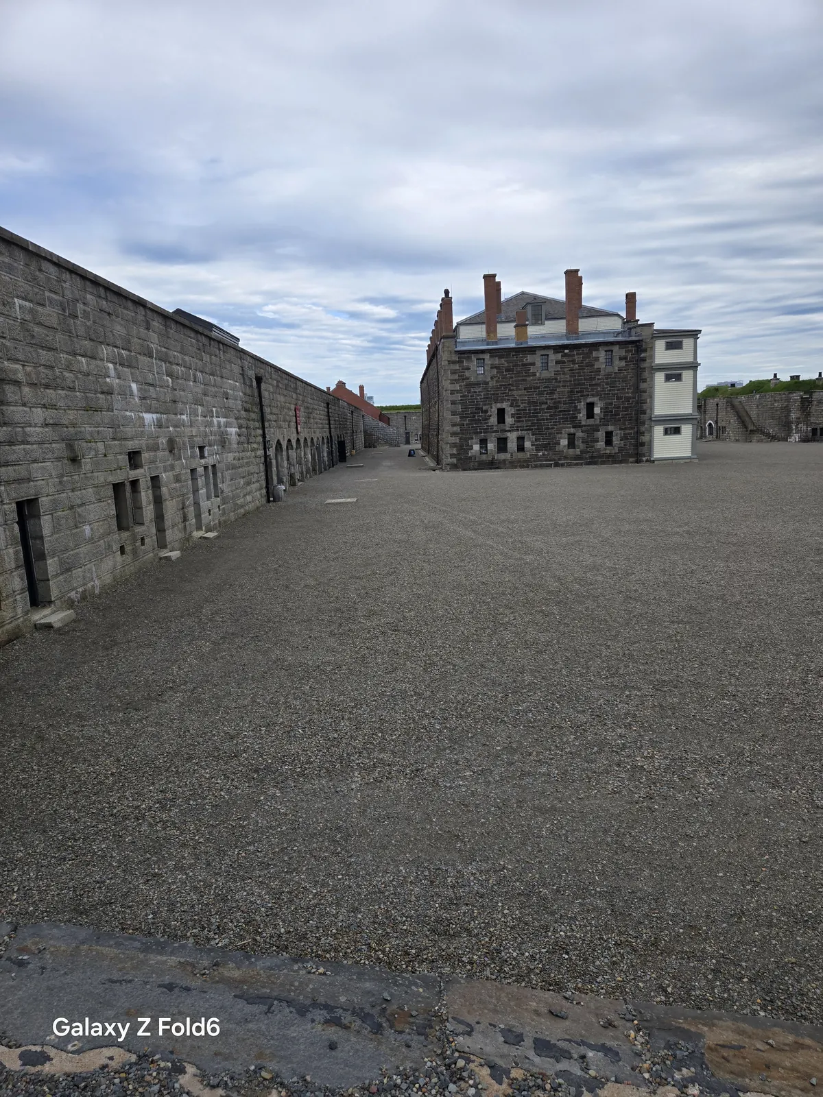 the cruise hq stone fortress courtyard with a dark brick building and chimneys at halifax citadel
