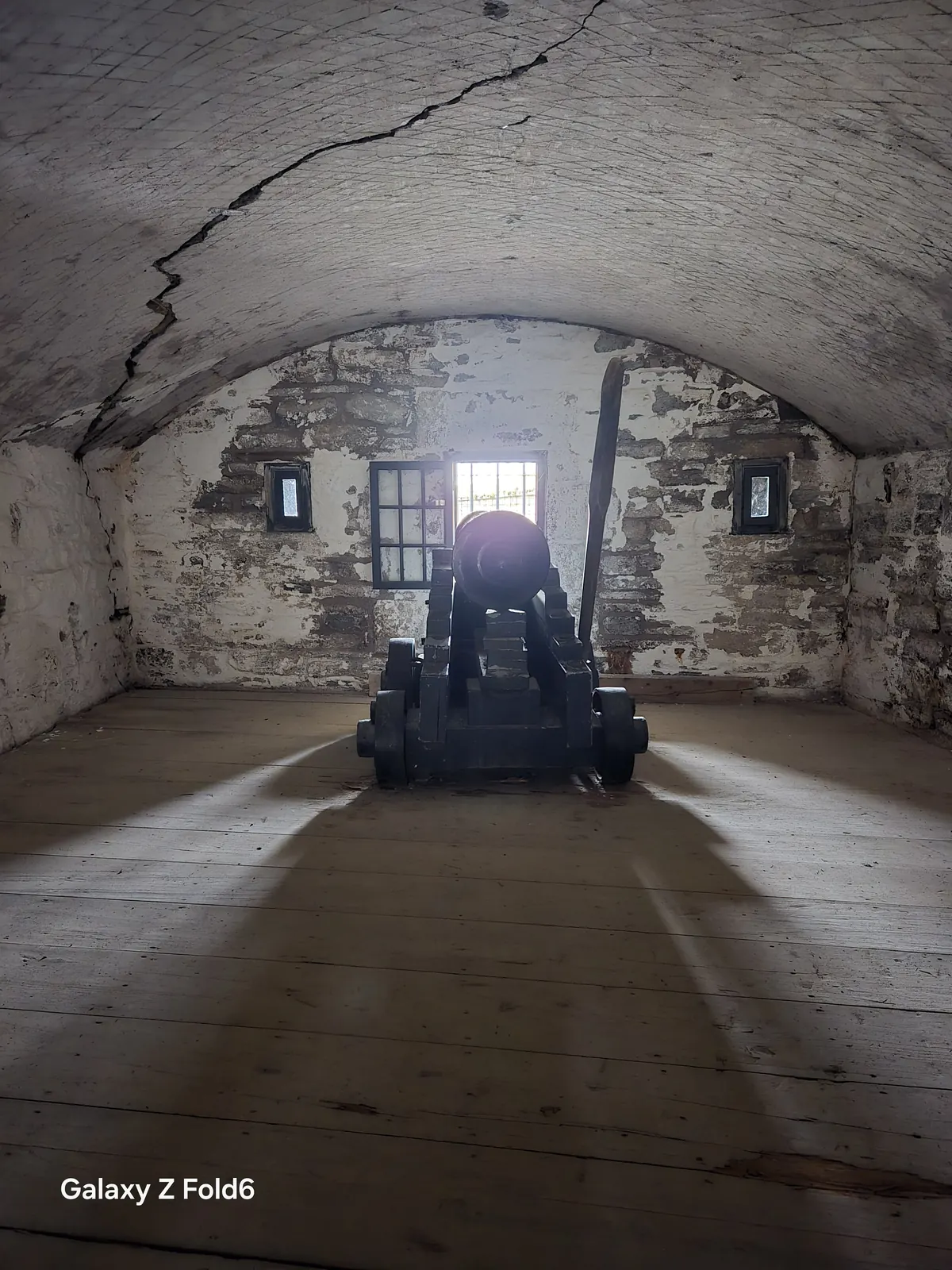 the cruise hq cannon aimed through a window in a whitewashed vaulted room at halifax citadel
