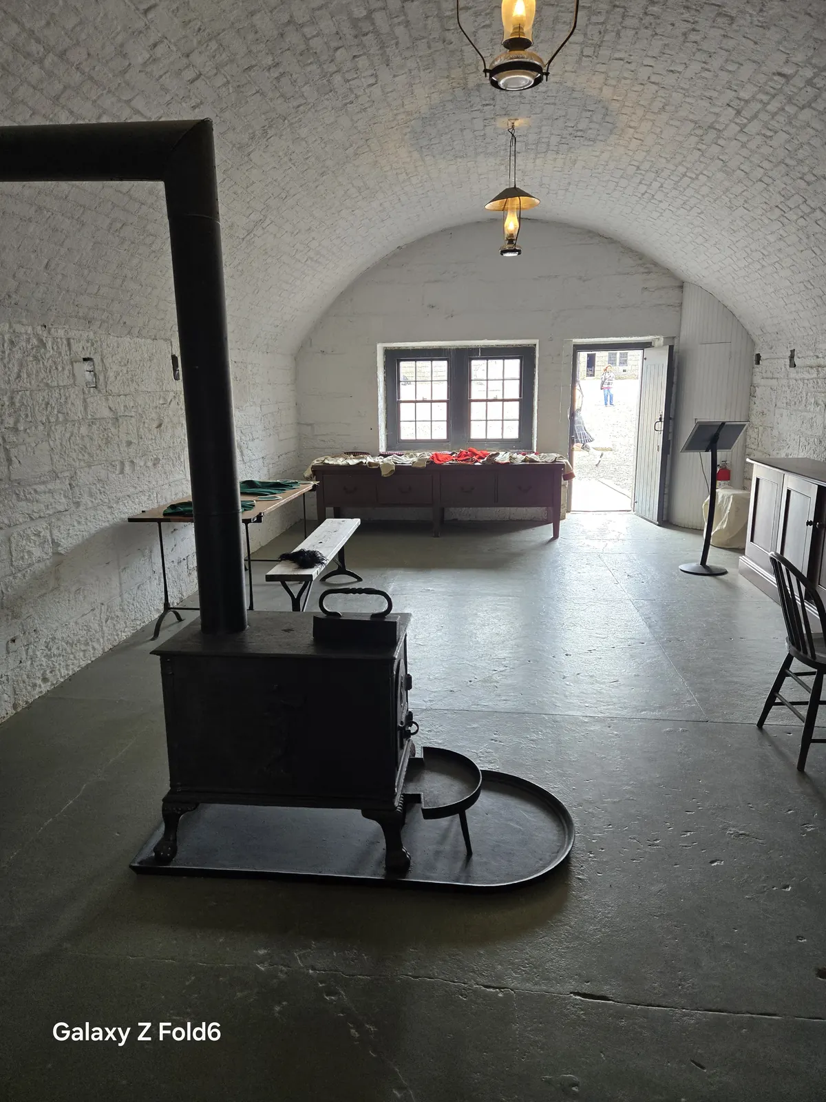 the cruise hq vaulted room with a cast iron stove and long table at halifax citadel