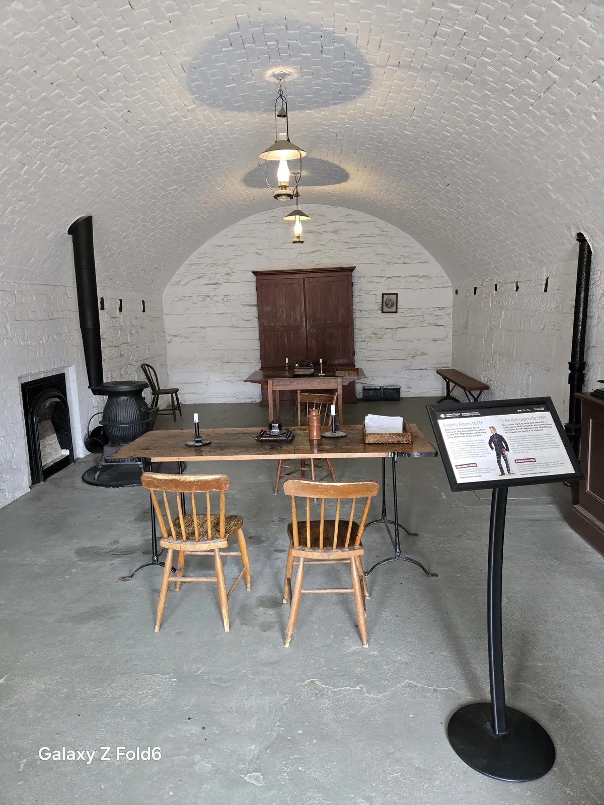 the cruise hq orderly room with a desk chairs and a fireplace at halifax citadel
