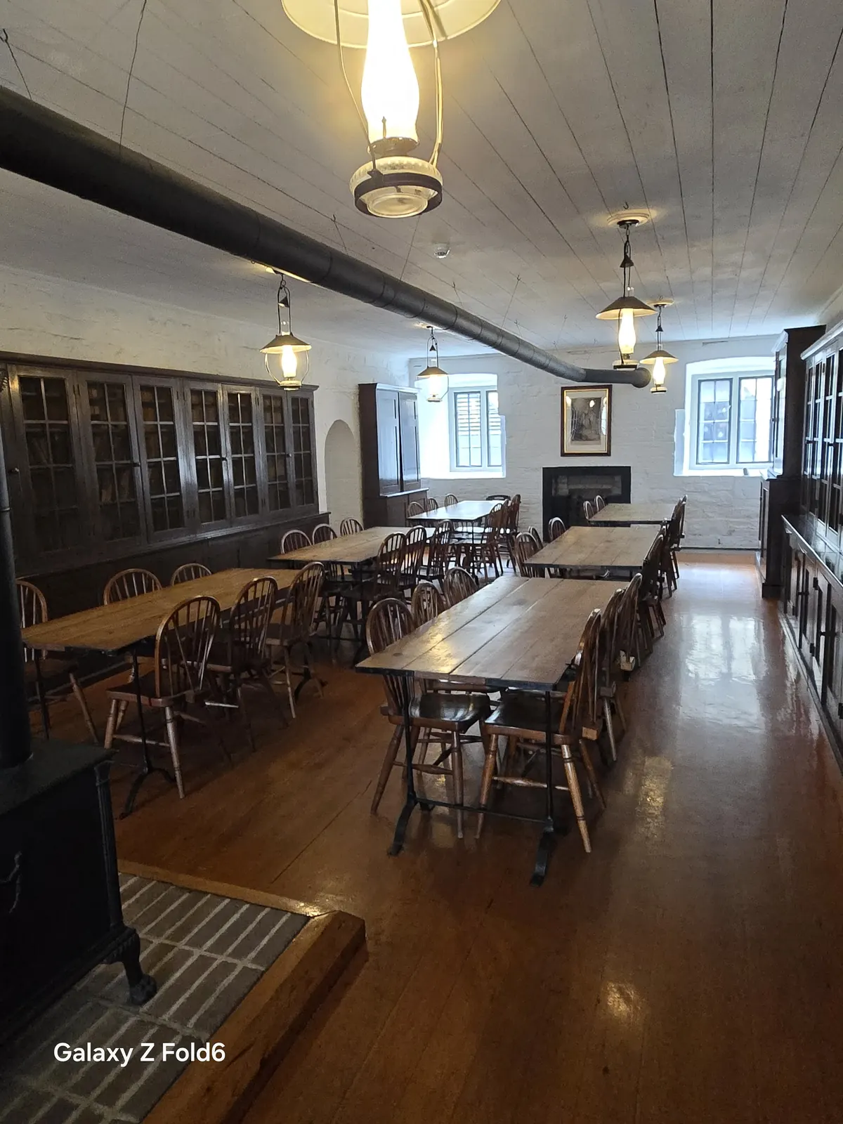 the cruise hq mess room with wooden tables chairs and hanging lamps at halifax citadel