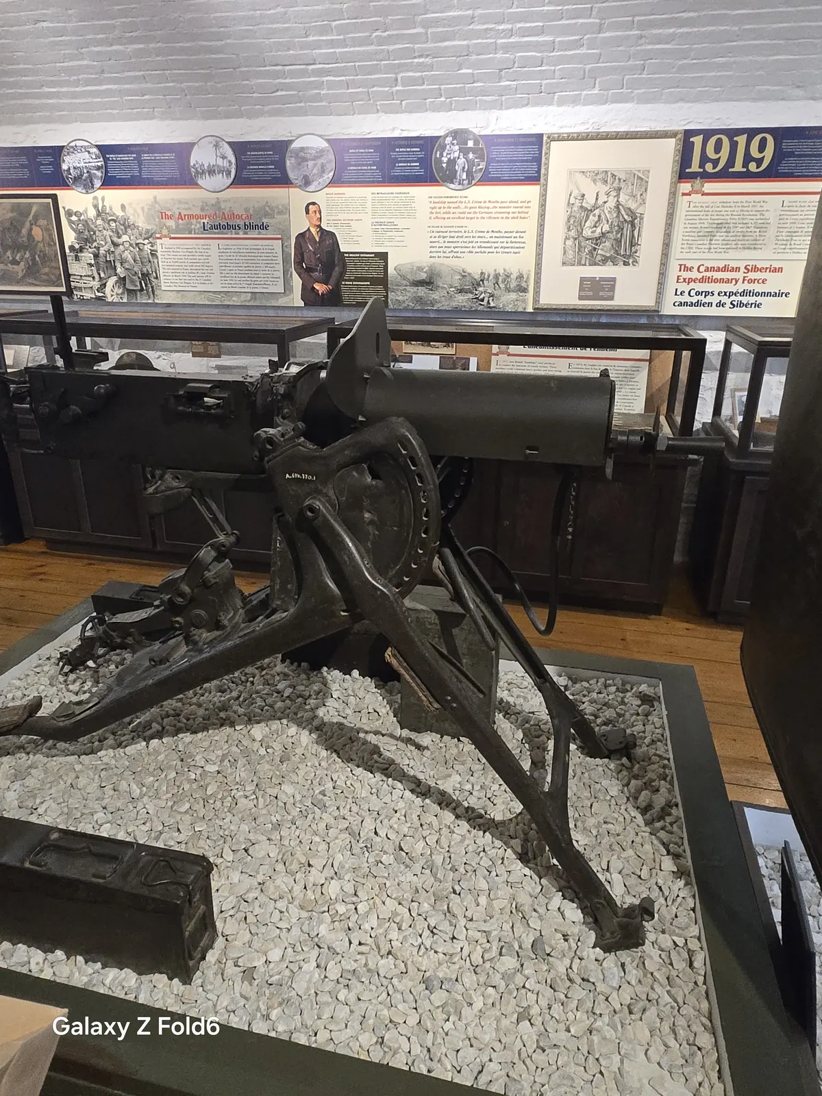 the cruise hq heavy machine gun on a tripod in a museum case at halifax citadel