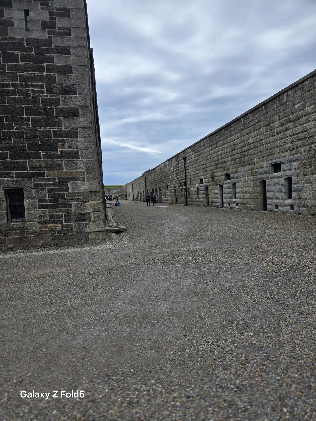 the cruise hq stone barracks building beside the gravel lane under a cloudy sky at halifax citadel