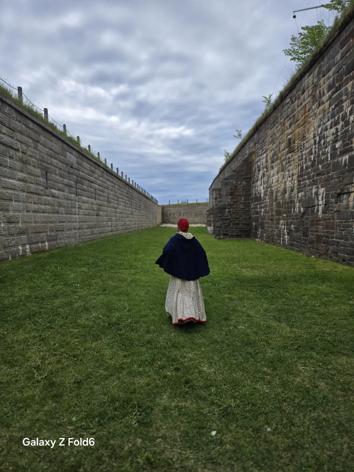 the cruise hq a guide in period dress walking along the grassy defensive ditch at halifax citadel