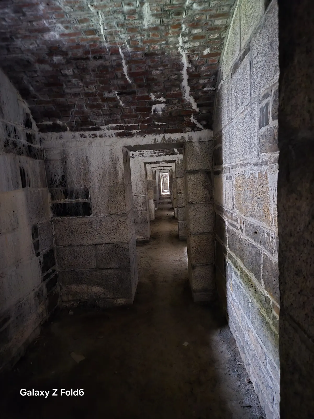 the cruise hq stone passage with a brick ceiling and doorways stretching into the distance at halifax citadel