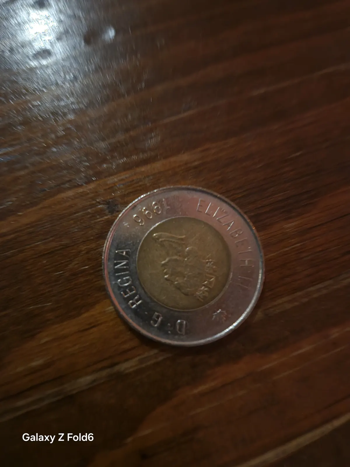 the cruise hq canadian two dollar coin on a polished wooden bar top at alexander keith's Brewery in Halifax