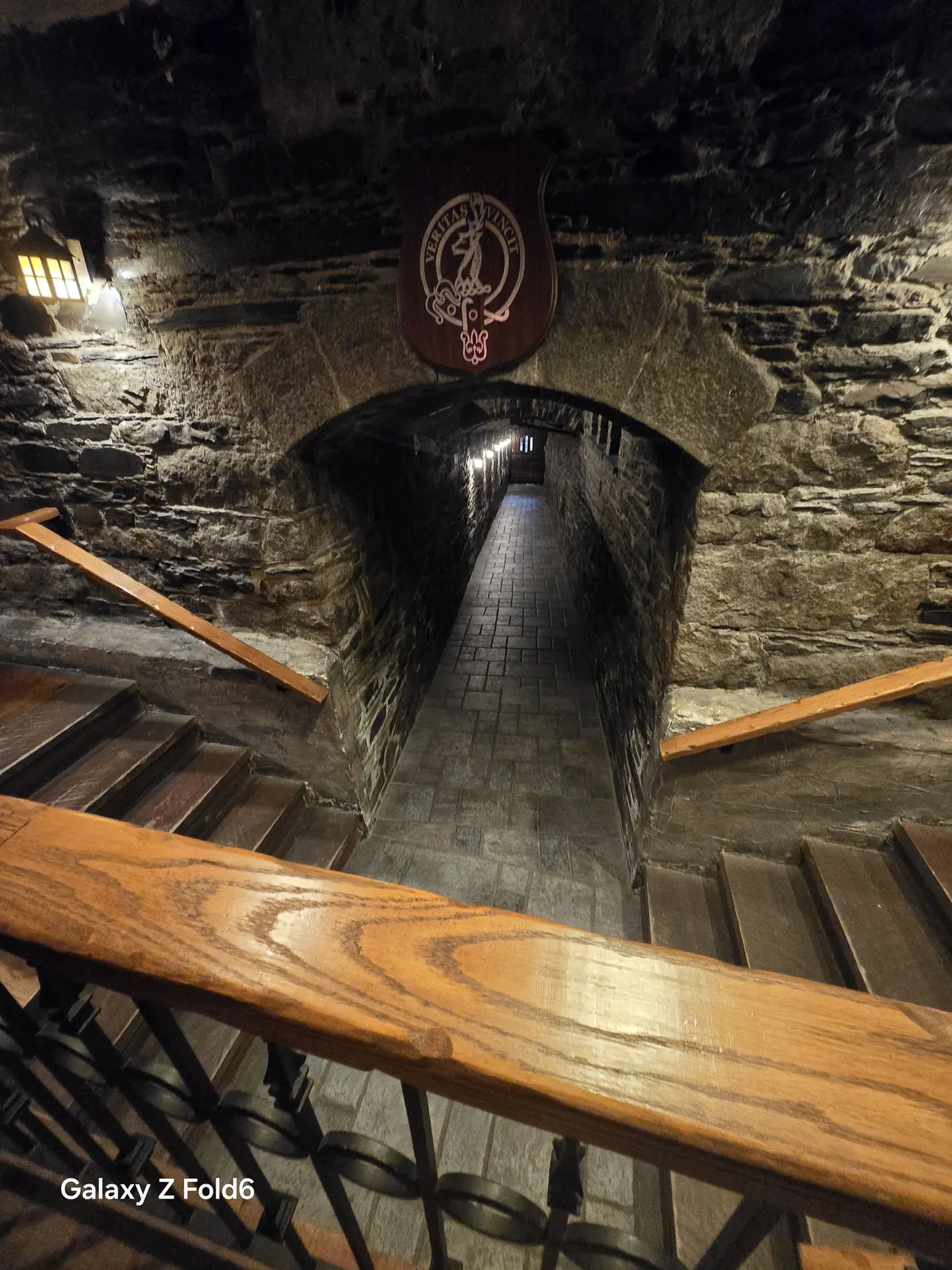 the cruise hq stairs leading down into a narrow arched stone tunnel under a crest at alexander keith's Brewery in Halifax