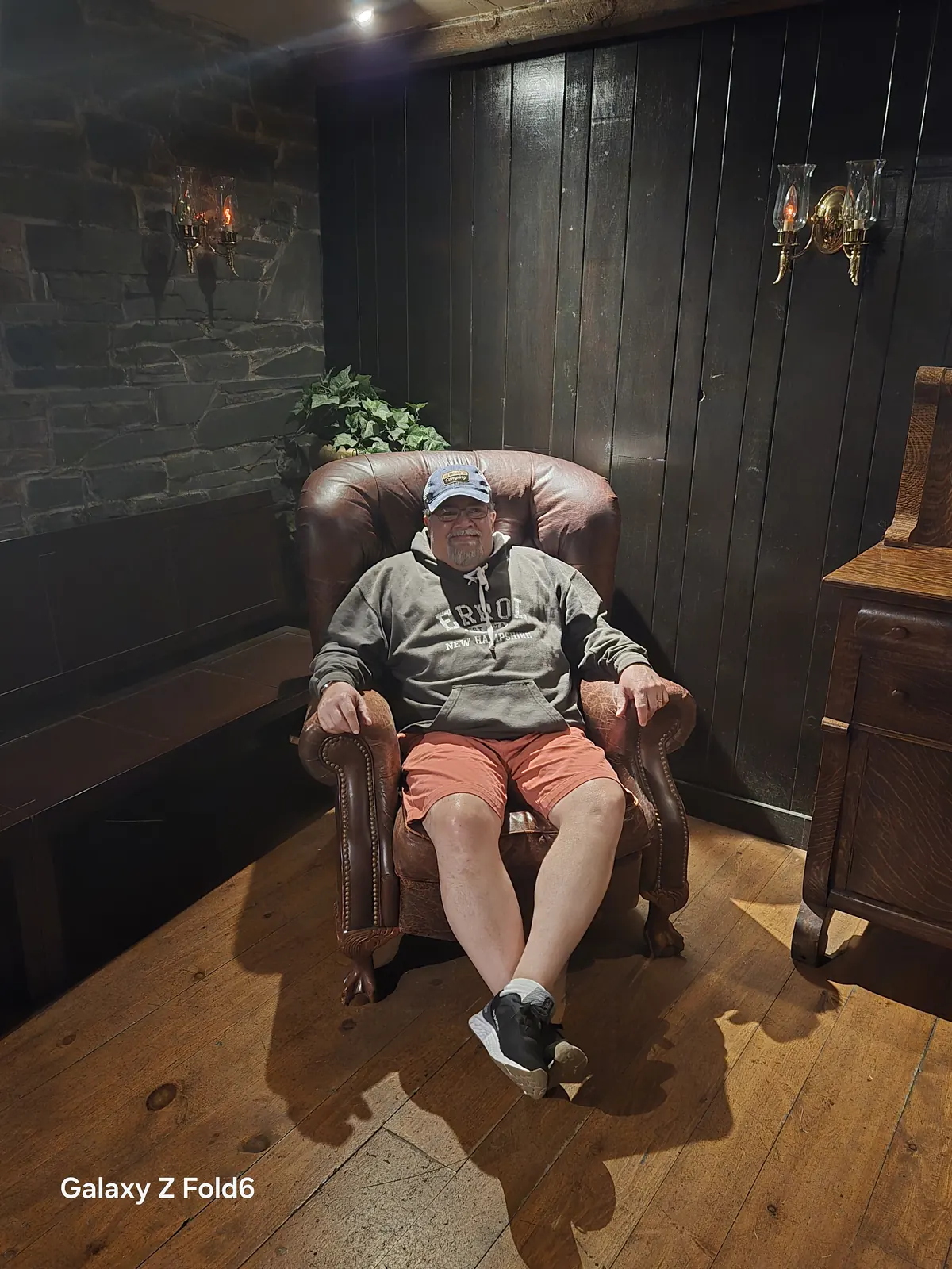 the cruise hq visitor seated in a leather wingback chair against dark wood panelling at alexander keith's Brewery in Halifax