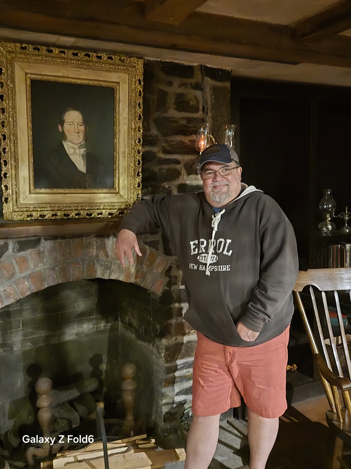 the cruise hq visitor leaning on a brick fireplace below a framed oil portrait at alexander keith's Brewery in Halifax