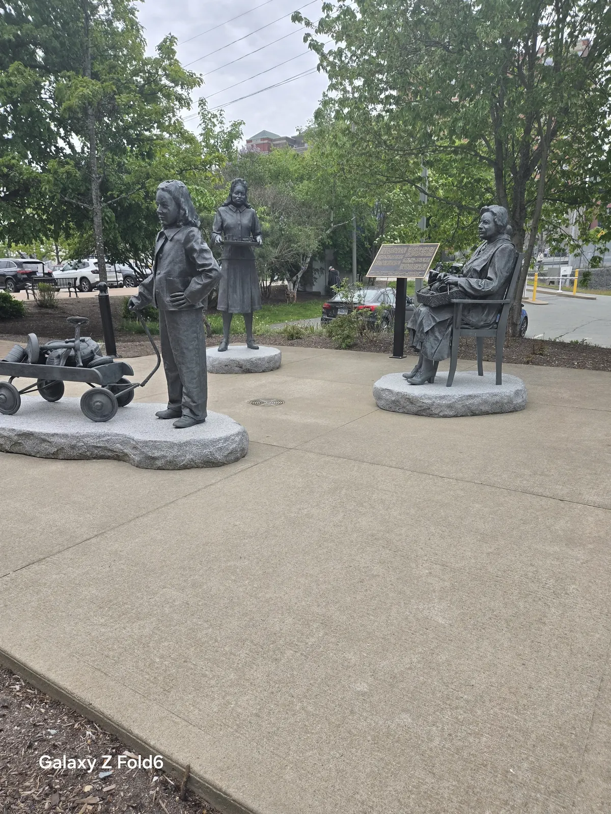 the cruise hq the volunteers monument by marlene hilton moore beside trees near the halifax seaport farmers' Market
